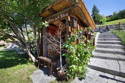 a small building with a bench in a garden at Maison Grange 1 in Pila