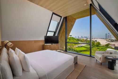Katara Hills Doha, Lxr Hotels & Resorts في الدوحة: غرفة نوم بسرير كبير ونافذة كبيرة