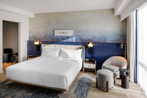 a bedroom with a white bed and a blue wall at The Morrow Washington Dc, Curio Collection By Hilton in Washington, D.C.