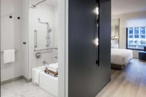 a bathroom with a shower and a bathroom with a bed at The Morrow Washington Dc, Curio Collection By Hilton in Washington