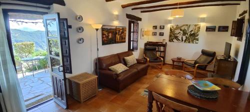 a living room with a couch and a table at Cortijo Opazo in Pórtugos