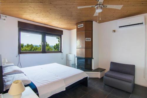 a bedroom with a bed and a window and a chair at Apartment Botta in Mimice
