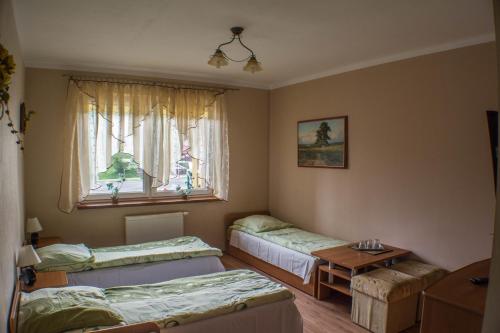 a room with three beds and a window at Ośrodek Pegaz in Duszniki Zdrój