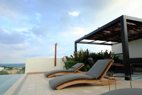 Spacious Studio, incredible rooftop with sea view في بلايا ديل كارمن: مجموعة من الكراسي موضوعة فوق المنزل