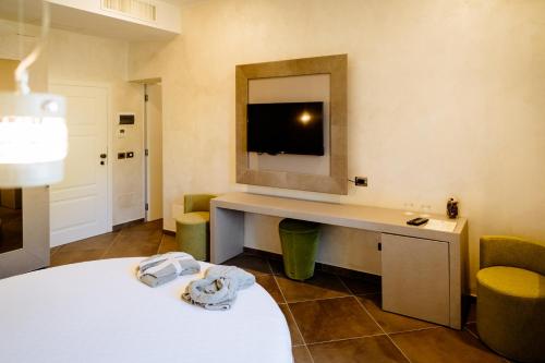 Habitación con cama y escritorio con TV. en Resort Faro di Punta Fenaio en Campese