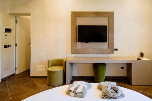 Habitación de hotel con escritorio y TV. en Resort Faro di Punta Fenaio en Campese