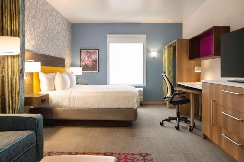科羅拉多斯普林斯的住宿－Home2 Suites By Hilton Colorado Springs I-25 Central，配有一张床和一张书桌的酒店客房