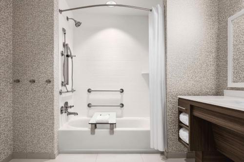Baño blanco con bañera y lavamanos en Home2 Suites By Hilton Colorado Springs I-25 Central, en Colorado Springs