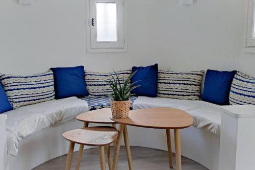 uma sala de estar com um sofá com almofadas azuis e uma mesa em Jolie Villa à 400m des plages de sable em La Plaine-sur-Mer