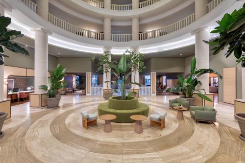 a lobby with a green couch and tables and plants at Domes Lake Algarve, Autograph Collection in Vilamoura