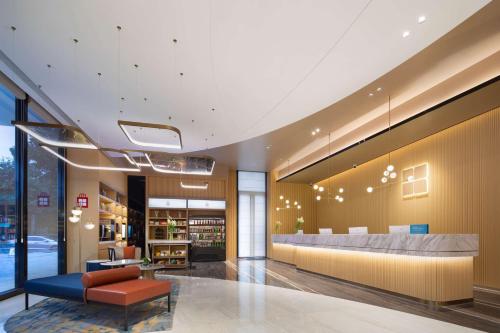 - un hall d'une bibliothèque avec un canapé et une table dans l'établissement Hilton Garden Inn Hangzhou Xiaoshan, à Hangzhou