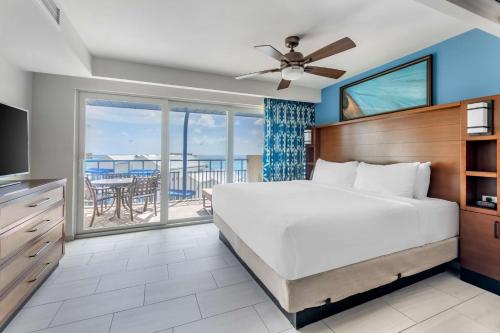 1 dormitorio con 1 cama grande y balcón en Hilton Vacation Club Flamingo Beach Sint Maarten en Simpson Bay