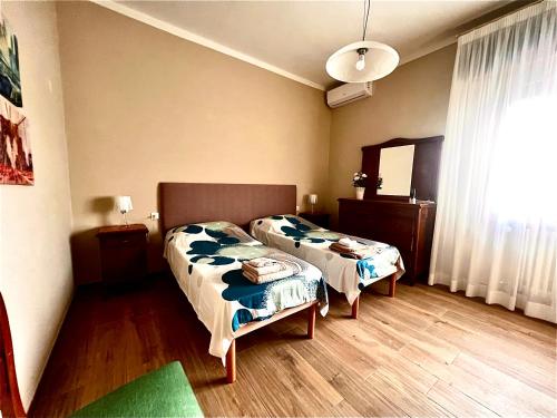 1 dormitorio con 2 camas y espejo en Villa Anna with pool and lift, en Capannori