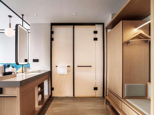 a bathroom with a pivot door and a sink at Hilton Garden Inn Hefei Binhu New District in Hefei