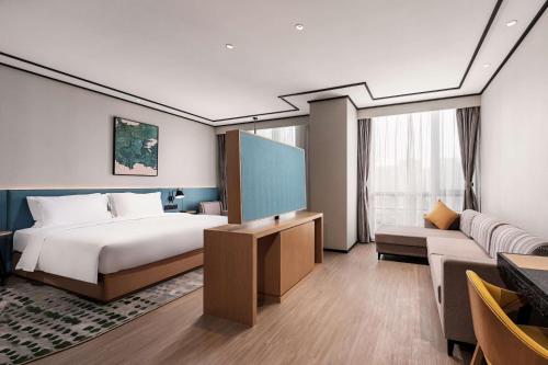 pokój hotelowy z łóżkiem i kanapą w obiekcie Hilton Garden Inn Hefei Binhu New District w mieście Hefei