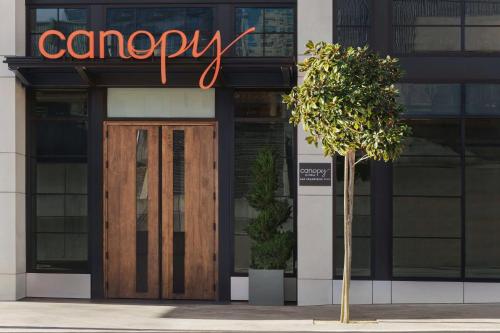 a building with a sign above a door and a tree at Canopy by Hilton San Francisco SoMa in San Francisco