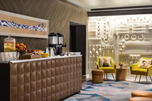 a restaurant with a counter and two yellow chairs at Canopy by Hilton San Francisco SoMa in San Francisco