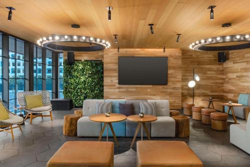 a lobby with a couch and a tv on a wall at Canopy by Hilton San Francisco SoMa in San Francisco