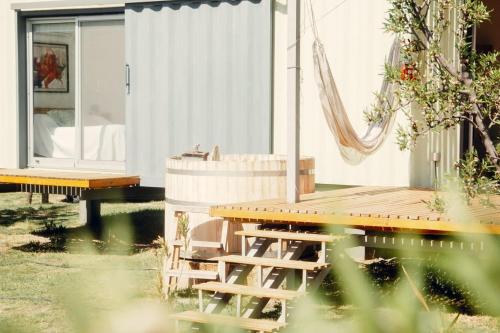 a house with a deck and a table and chairs at Las Guaras Valle de Uco in Tunuyán