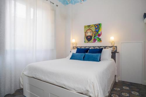 a bedroom with a large white bed with blue pillows at A Ugghia- I Mori in Fiumefreddo di Sicilia