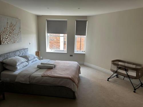 a bedroom with a bed and a desk and two windows at Modern 1bedflat Kensington in London