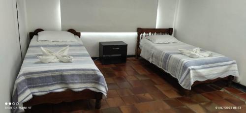 - deux lits assis l'un à côté de l'autre dans une pièce dans l'établissement Hermosa Casa Campestre en Villeta, à Villeta