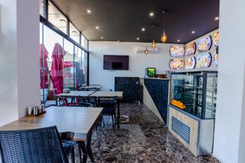 Acar Airport Hotel في Arnavutköy: مطعم به طاولات وكراسي ومنضدة