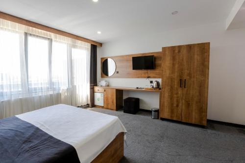a bedroom with a bed and a desk with a microwave at Acar Airport Hotel in Arnavutköy