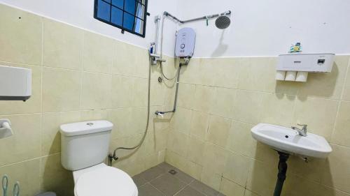 a bathroom with a toilet and a sink at Sporting Homestay in Semporna