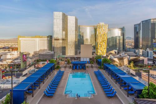 a pool with blue loungers and a city skyline at Hilton Vacation Club Polo Towers Las Vegas in Las Vegas