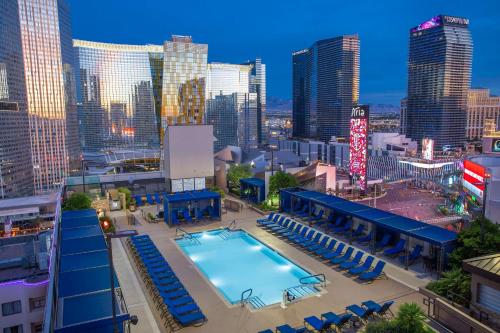 a swimming pool with chairs and a city skyline at Hilton Vacation Club Polo Towers Las Vegas in Las Vegas