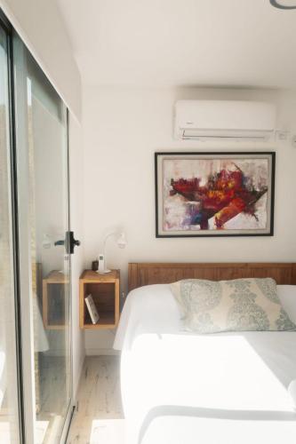 a bedroom with a bed and a painting on the wall at Las Guaras Valle de Uco in Tunuyán