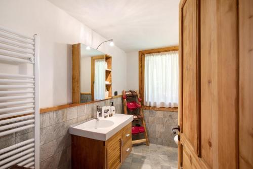 La salle de bains est pourvue d'un lavabo et d'un miroir. dans l'établissement Maison Grange 4, à Gressan
