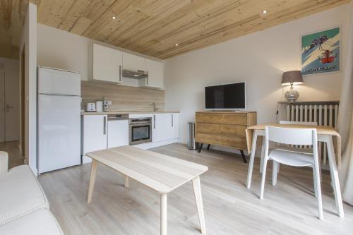 - une cuisine et une salle à manger avec une table et des chaises dans l'établissement Résidence Les Périades, à Chamonix-Mont-Blanc