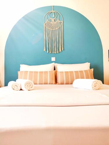 Cama en habitación con pared azul en KR Apartments, en Aliki