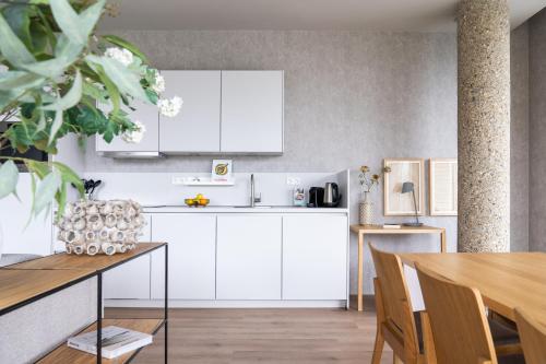 a kitchen with white cabinets and a wooden table at 348 Suites Short Stay in The Hague