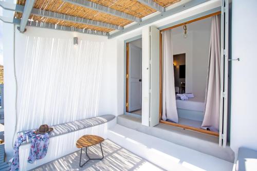 a room with a bench and a window at Terra White Seaview Pool Apartments & Suites in Mikonos