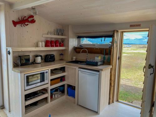 a small kitchen in a tiny house with a window at The Surf Shack in Camber