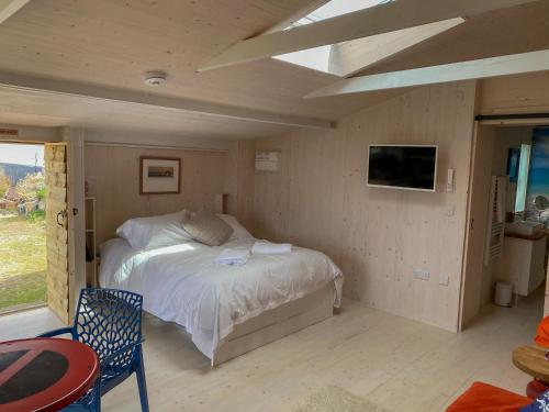 a bedroom with a bed in a room with a tv at The Surf Shack in Camber