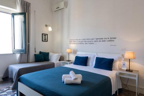 two beds in a room with blue and white at Casa dei Ré in Siracusa