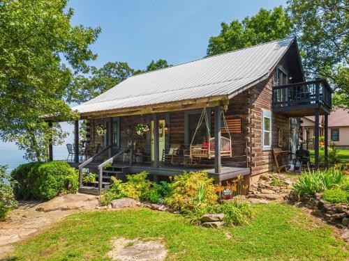 eine Blockhütte mit einem Metalldach und einer Terrasse in der Unterkunft Eagles Perch - Mentone's #1 Vacation Rental! in Mentone