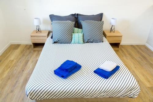 - un grand lit avec 2 serviettes bleues dans l'établissement #36 Studio liberté, 5 minutes de la plage/AC, à Nice