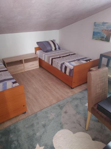 a small bedroom with two beds and a chair at Vila Sipovac in Budva