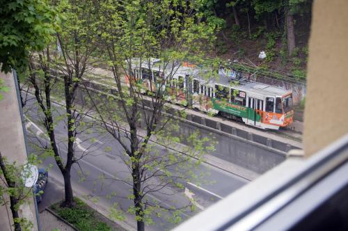 a train is on the tracks near a street at Budget Hotel Ekotel in Lviv