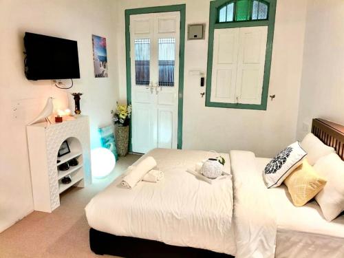 喬治市的住宿－Le Meilleur，一间卧室设有一张床、一台电视和一个窗口。