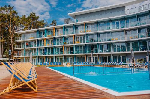 a hotel with a pool in front of a building at Hotel Linea Mare in Pobierowo