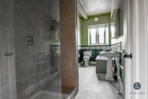 a bathroom with a shower and a sink at Poxwell Manor West Wing - Exclusive Dorset Retreat 
