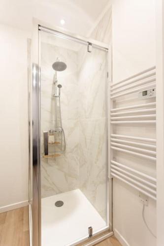 une douche avec une porte vitrée dans une salle de bain dans l'établissement #38 Promenade Studio : AC 2 mins de la Plage, à Nice