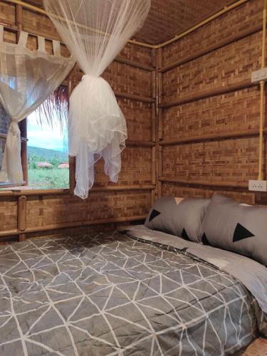 a bedroom with a bed in a room with a window at บ้านสวนกางโต้ง Ban Suan Kang Tong in Chom Thong