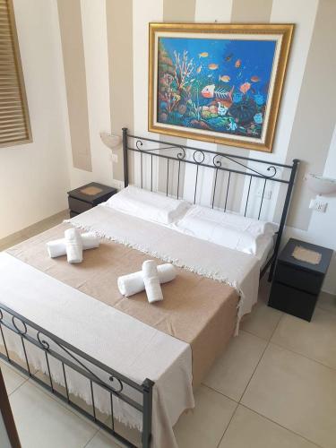a bedroom with a bed with a painting on the wall at Chalet del Mare in Porto Cesareo